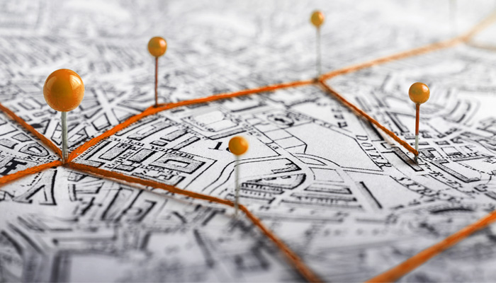 A monochromatic map is marked with bright orange lines and spherical pins to highlight Intoxalock locations.