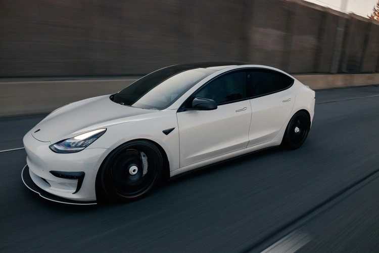 White electric vehicle driving on a highway