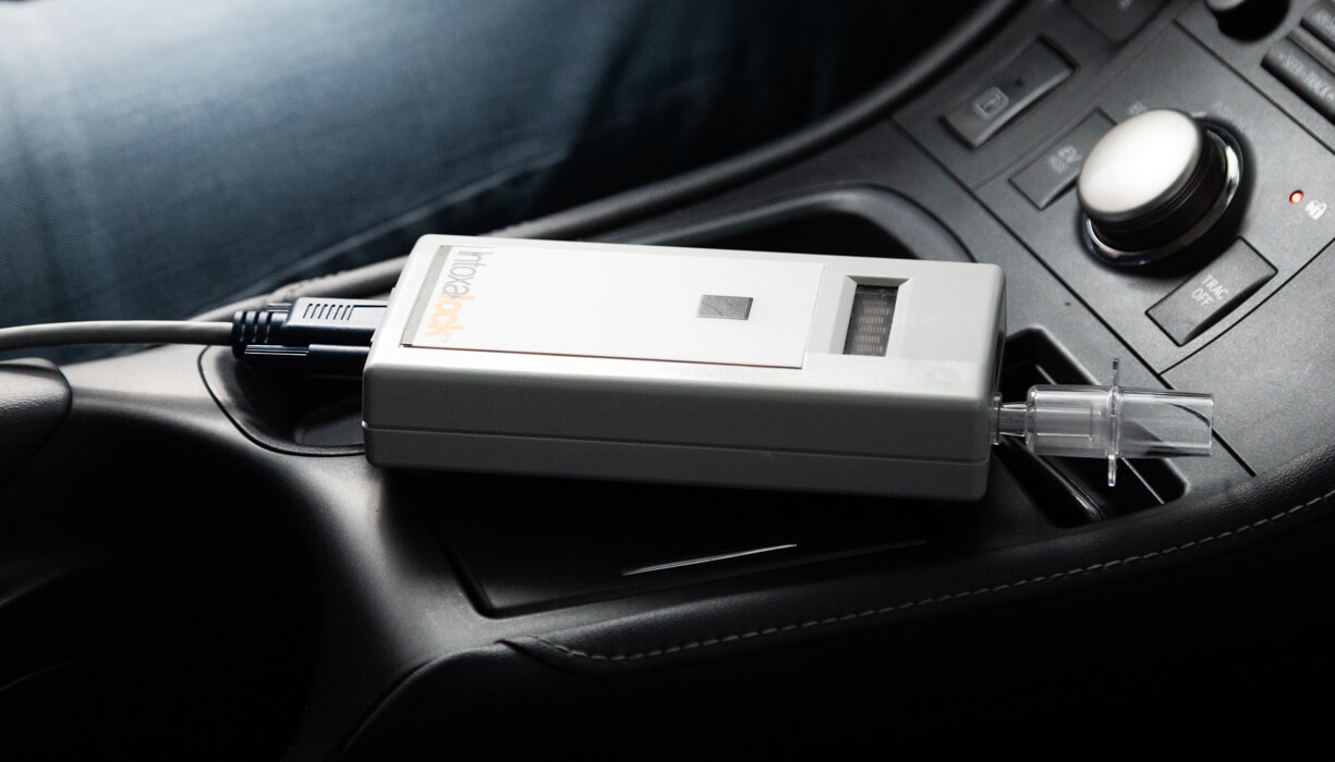 An Intoxalock ignition interlock device laying in the center console of a vehicle.