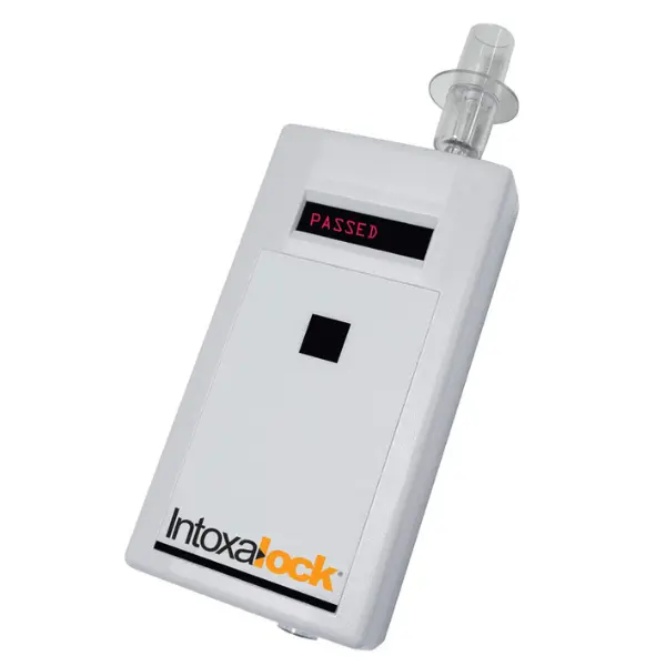 Intoxalock interlock system displaying a 'PASSED' message, with an attached mouthpiece for breath alcohol testing
